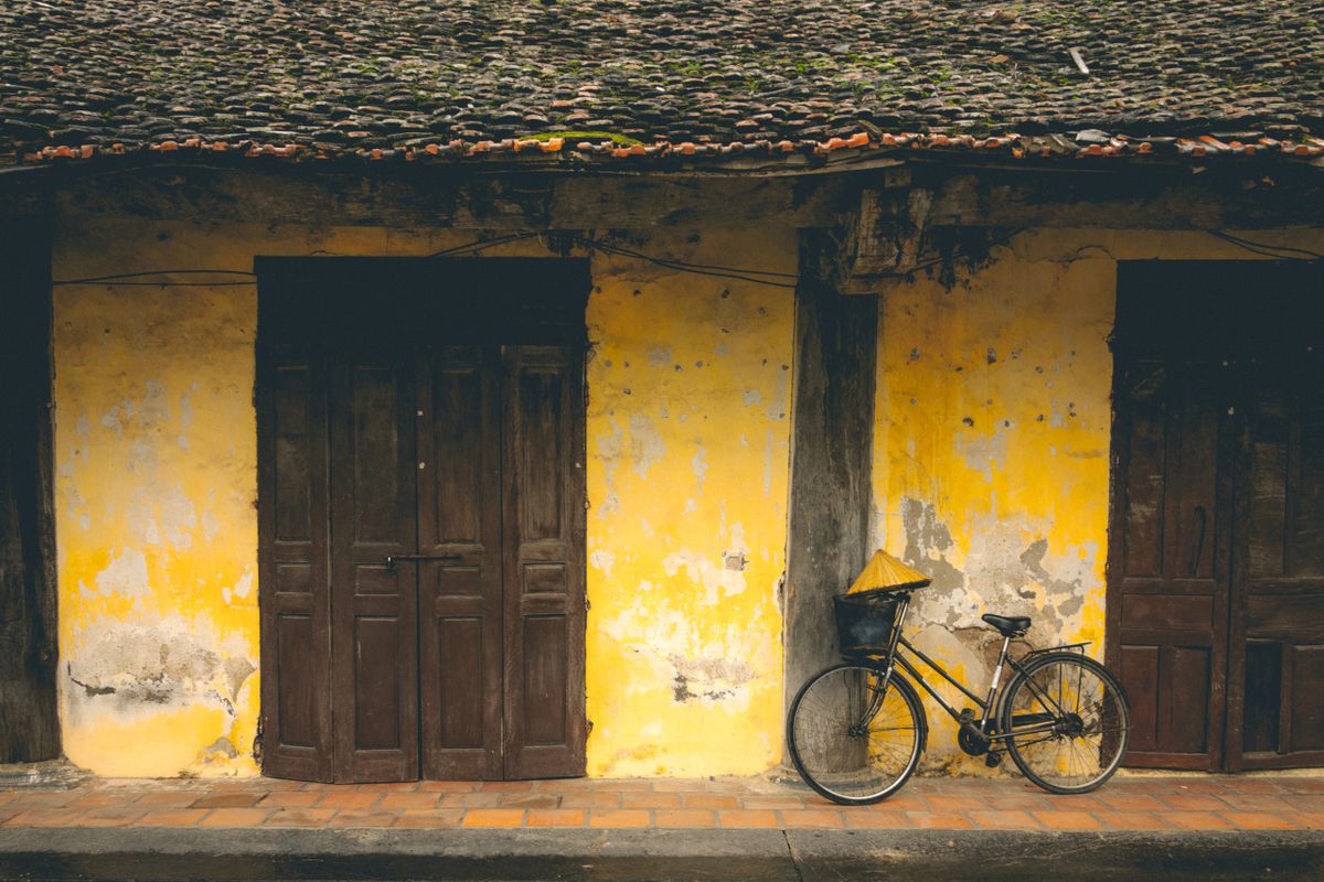 một chiếc xe đạp đậu trước tòa nhà màu vàng ở Ninh Bình