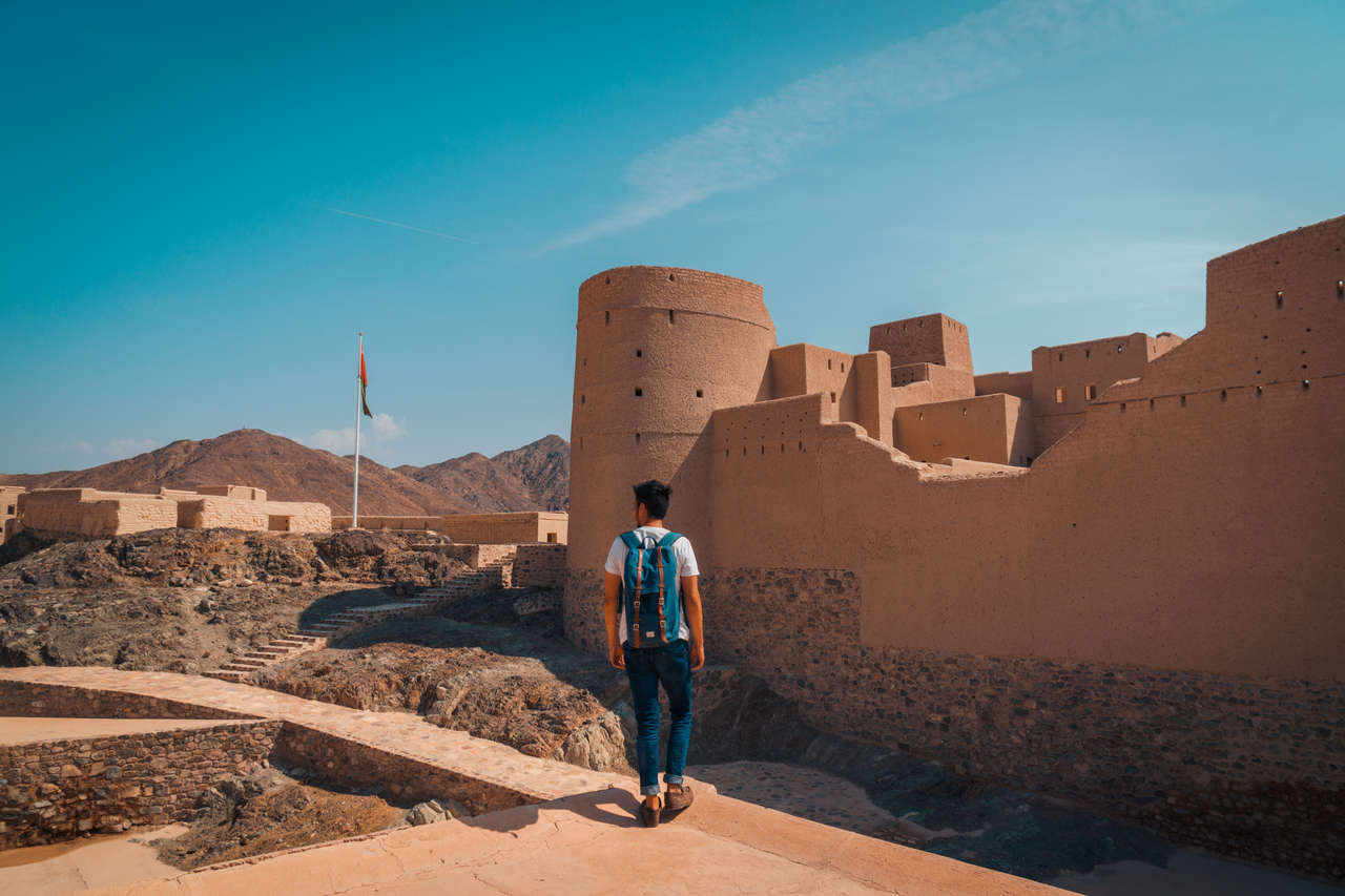 Một người đứng trên bức tường của pháo đài Bahla ở Oman
