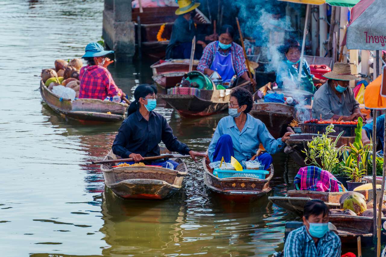 Người Thái nói chuyện với nhau trên những chiếc thuyền gỗ tại chợ nổi ở Ratchaburi