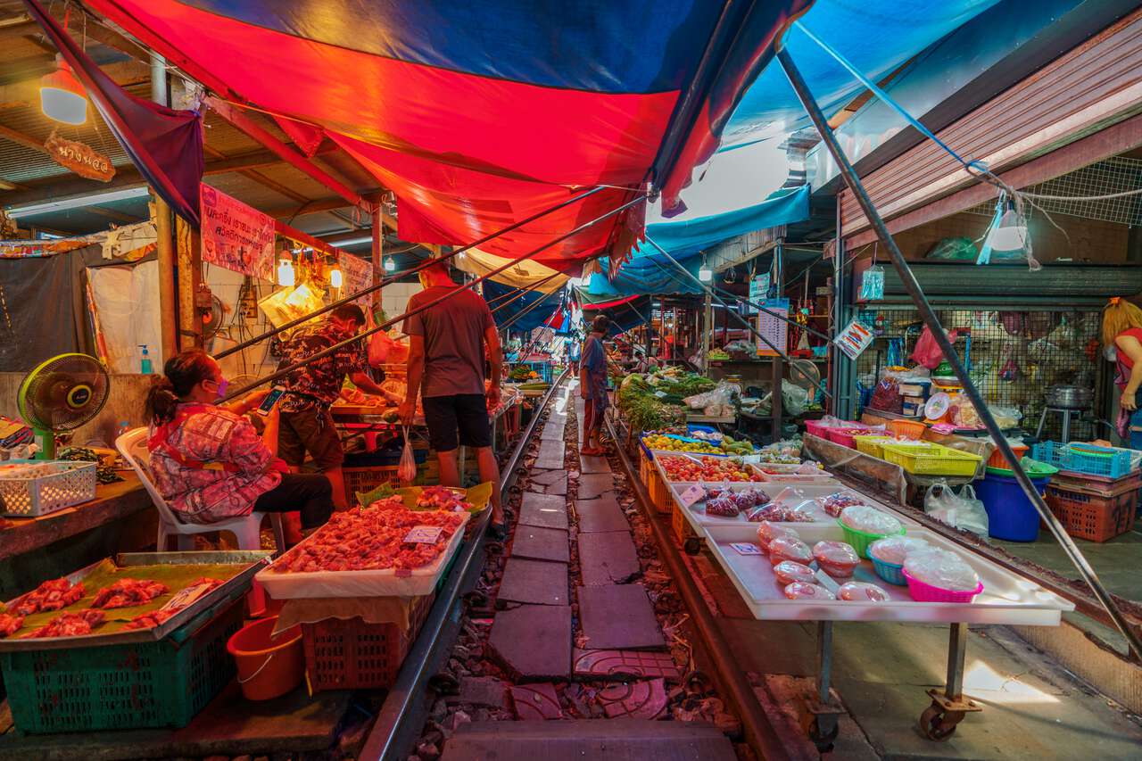 Chợ tươi sống trên đường ray ở Chợ xe lửa Mae Klong ở Samut Songkram, Thái Lan