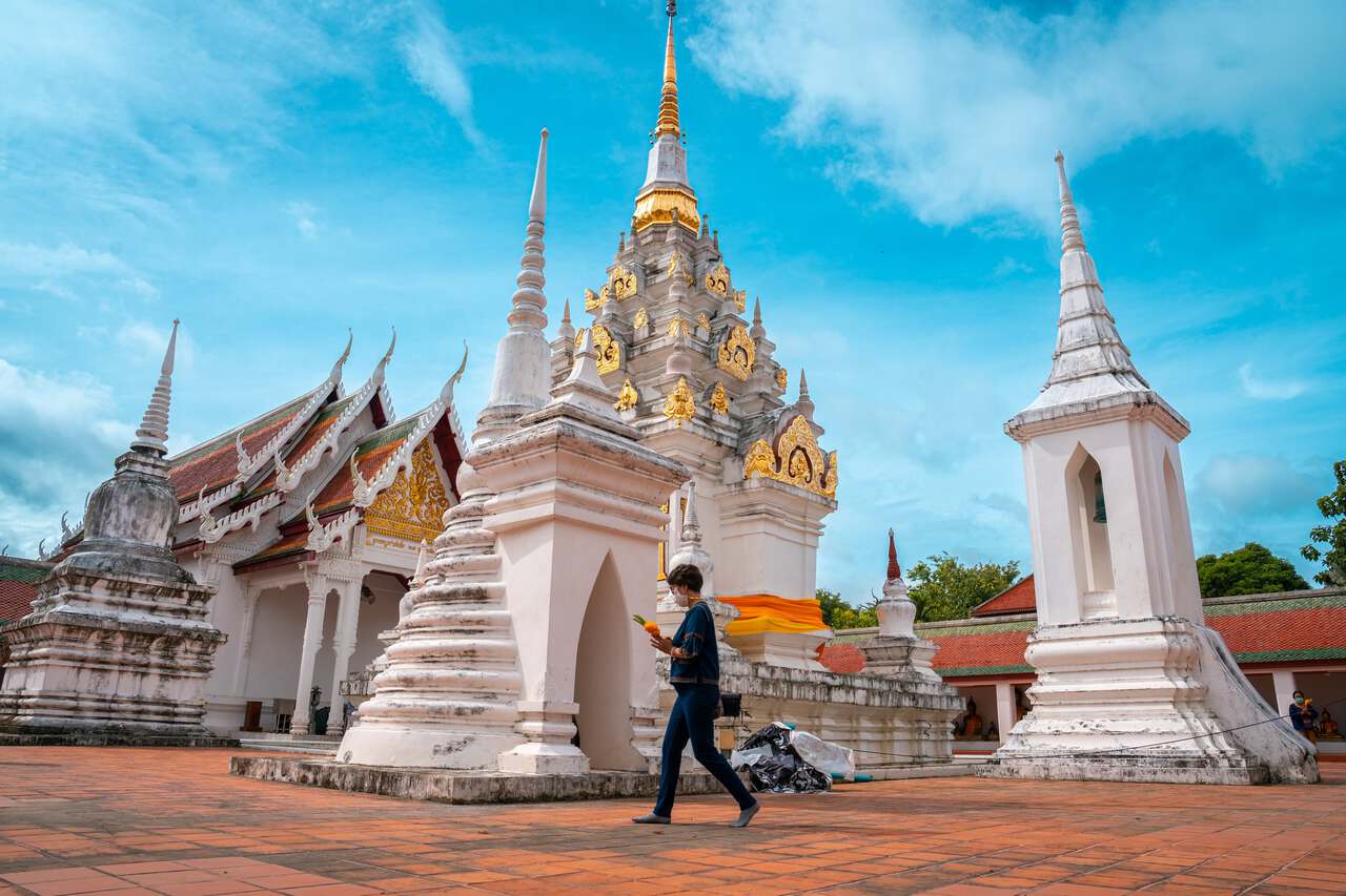 Một người đi bộ xung quanh cầu nguyện tại Wat Phra Borommathat Chaiya ở Surat Thani