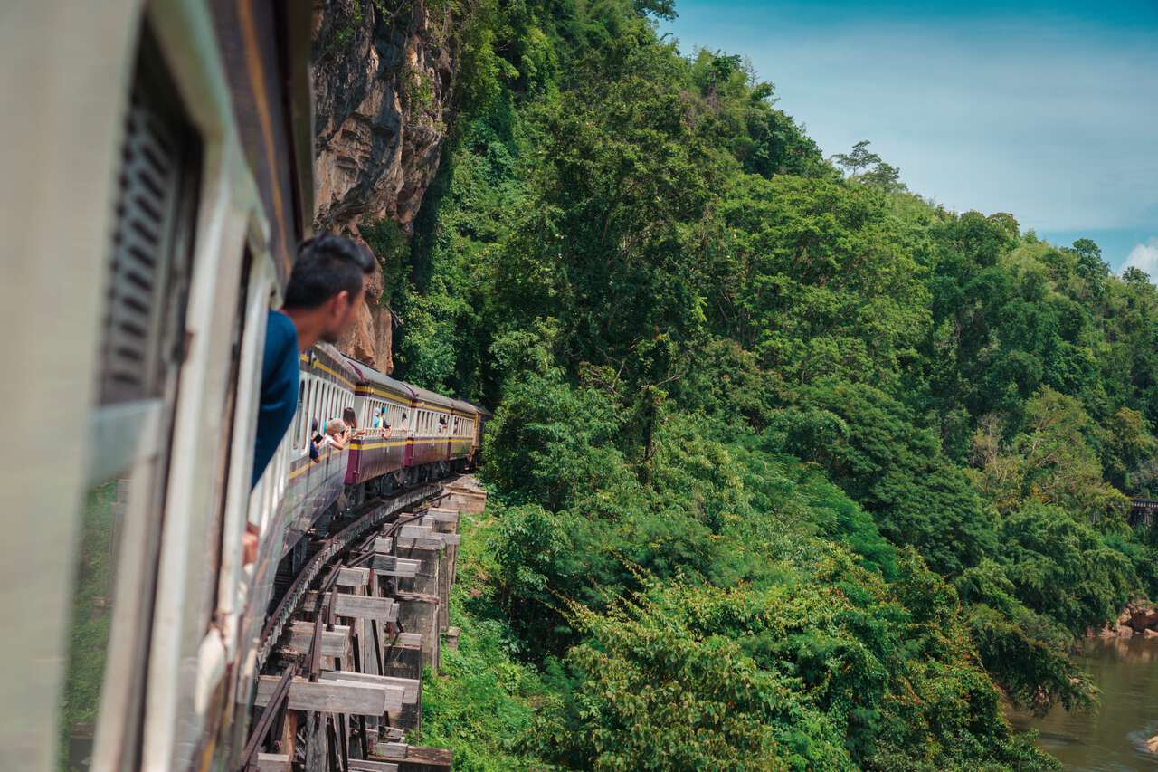 Một người đi chơi trên một chuyến tàu đi dọc theo cây cầu gỗ ở đoạn Đường sắt Tử thần Tham Krasae ở Kanchanaburi