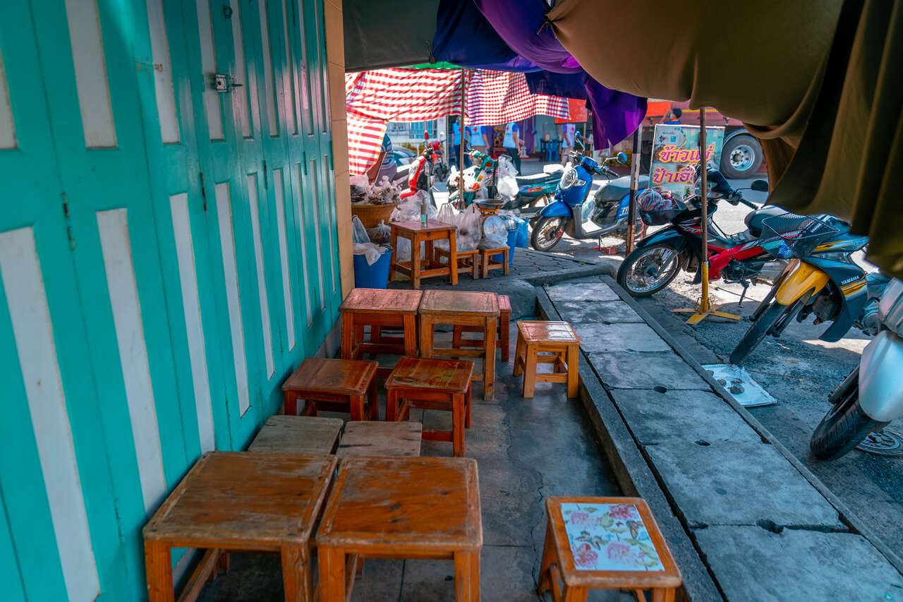 Những chiếc bàn nhỏ tại quầy thức ăn đường phố Pa Auen ở Phetchaburi, Thái Lan