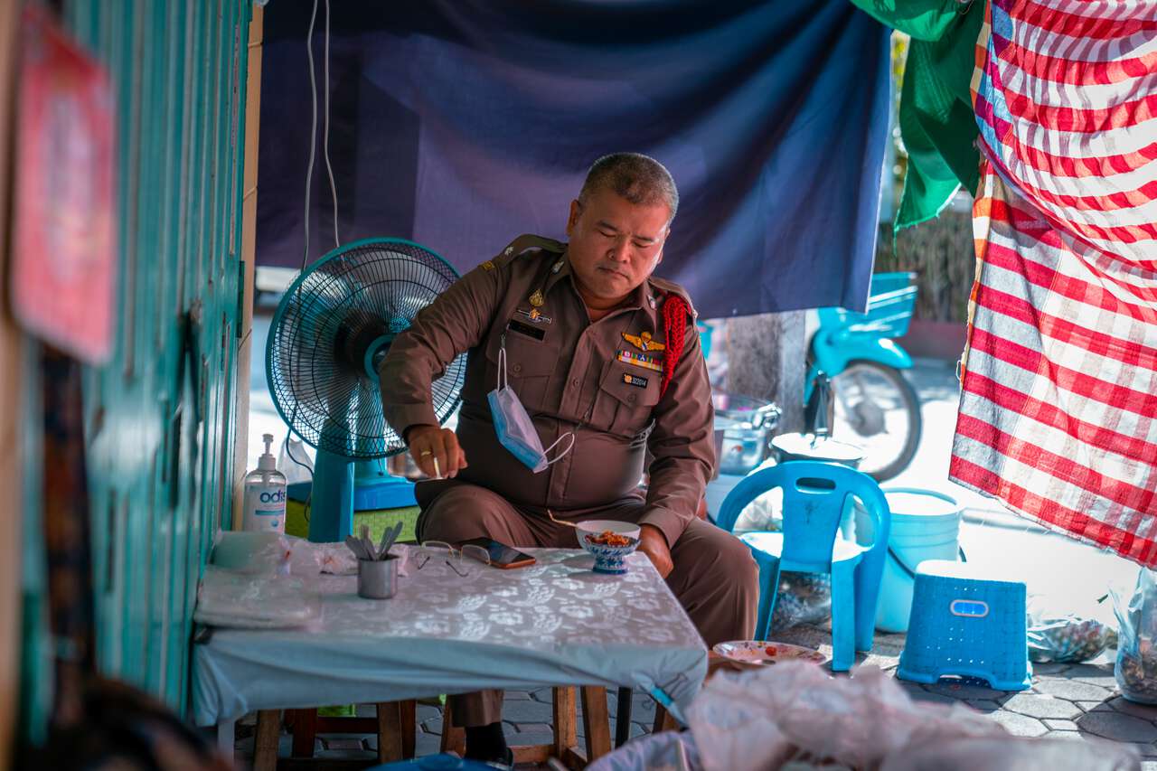 Một cảnh sát thưởng thức món Khao Chae tại gian hàng ẩm thực đường phố Pa Auen ở Phetchaburi, Thái Lan